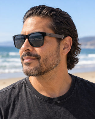 Pismo Beach polarized sunglasses worn by a man by the surf at Pismo Beach